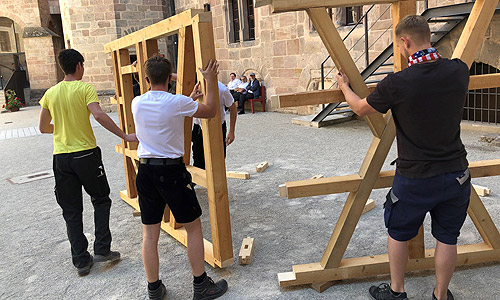 Bild: Schüler der Berufsschule 11 Nürnberg und ihr Lehrer Friedrich Müller bauen eine Fachwerkwand auf.